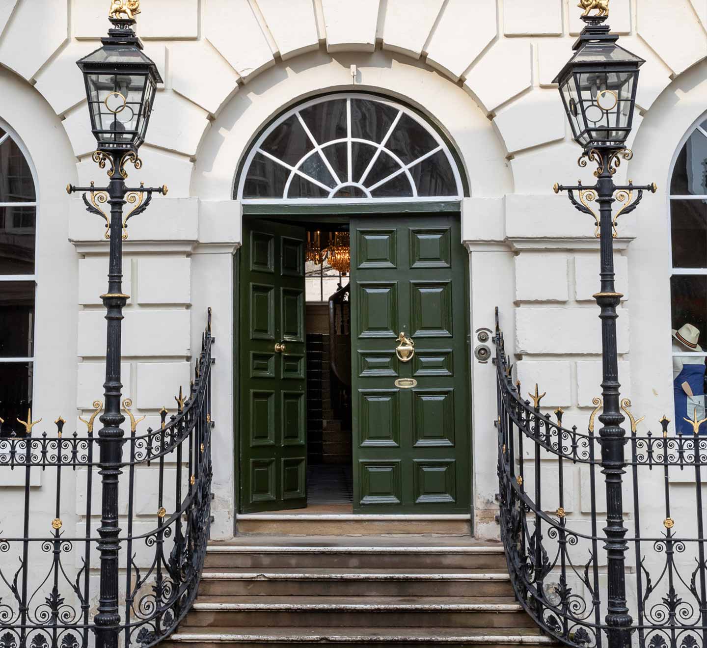 Entrance used for accessing the House, shows the white brick exterior of Mansion House with a Green door