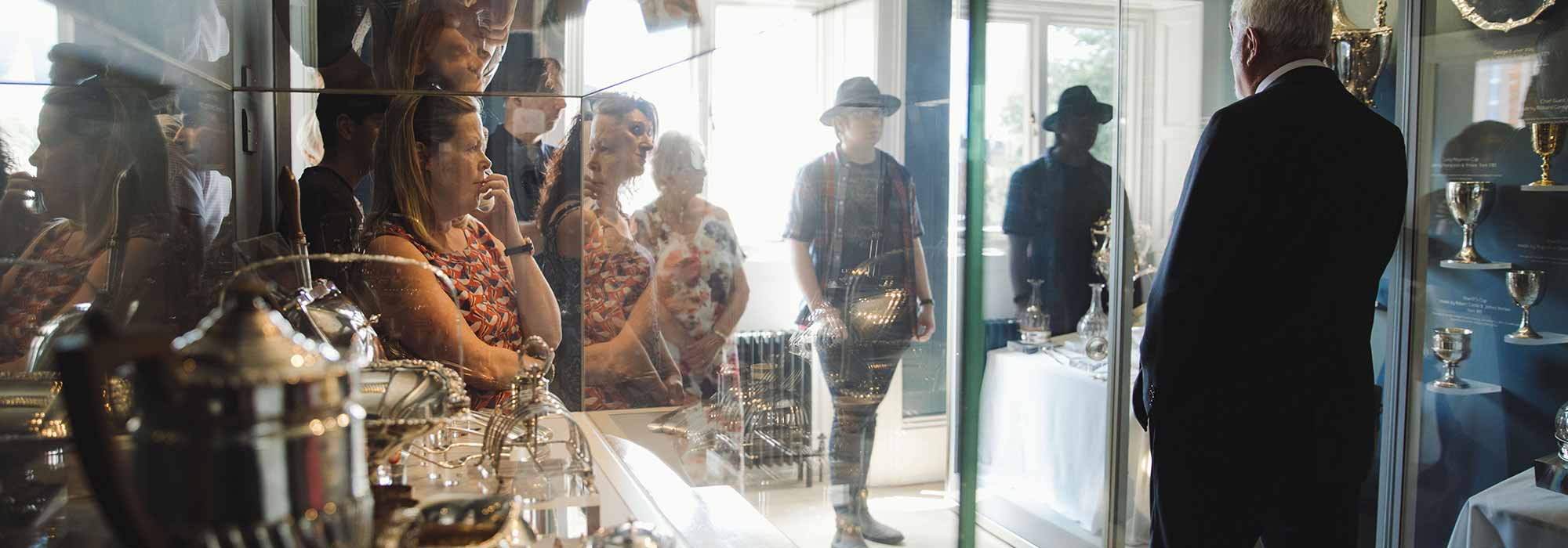 A group of people listen attentively to a guide at the Mansion House