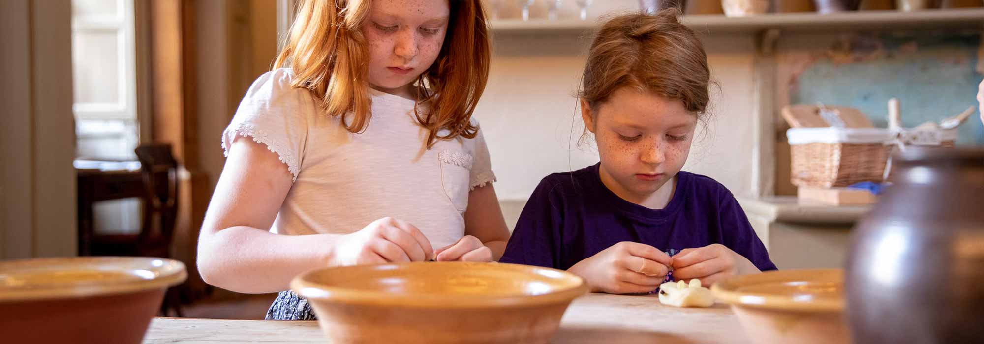 Two children are depicted learning how to cook