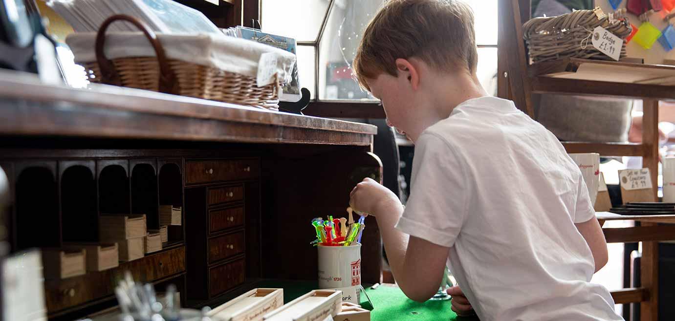 A young boy chooses the stationary he would like to use for his project