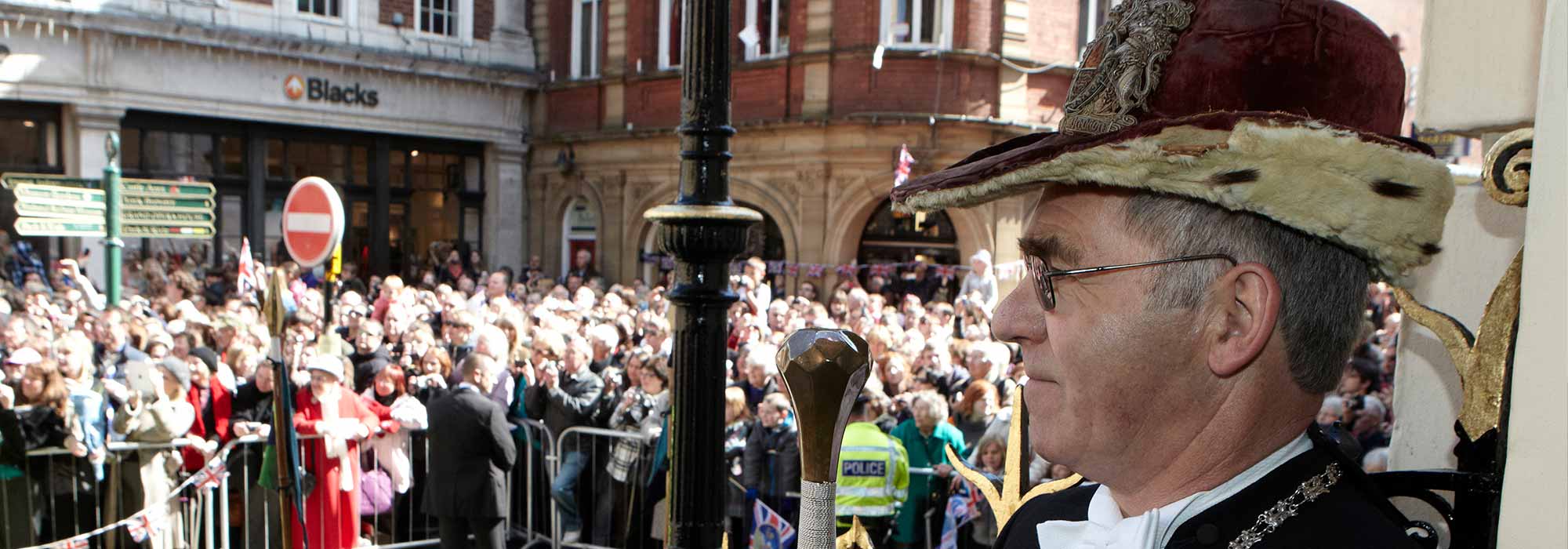 A member of the civic party surveys a crowd outside the Mansion House.