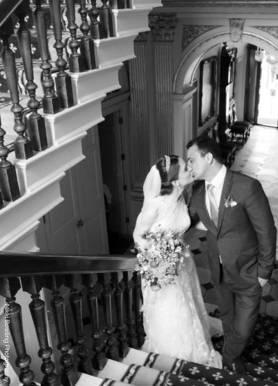Bride and groom kissing on staircase inside Mansion House