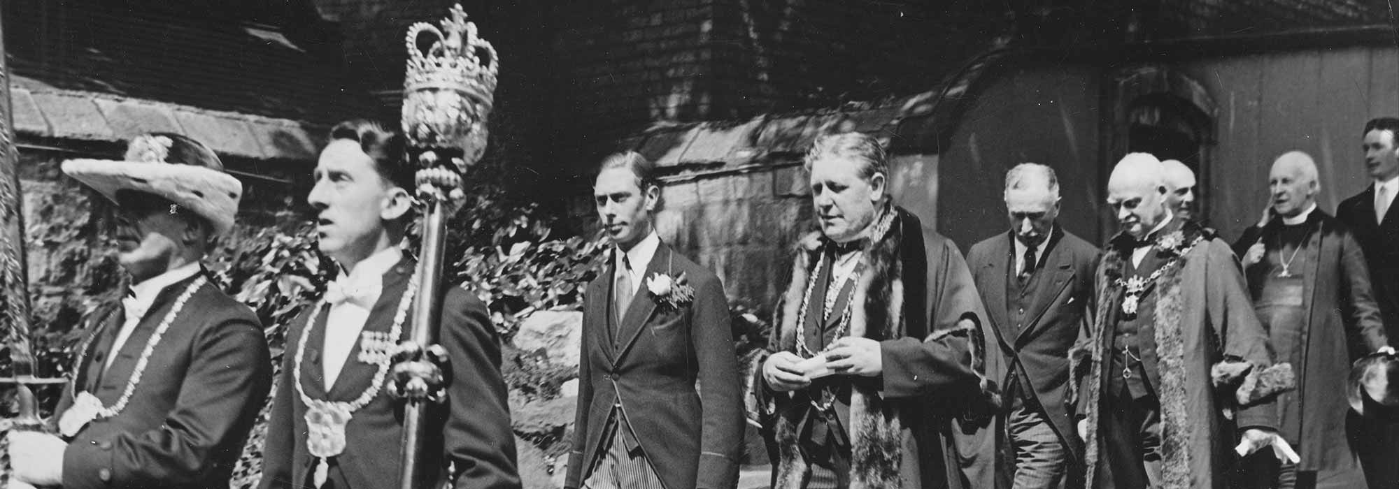 A black and white photograph showing a civic party procession.