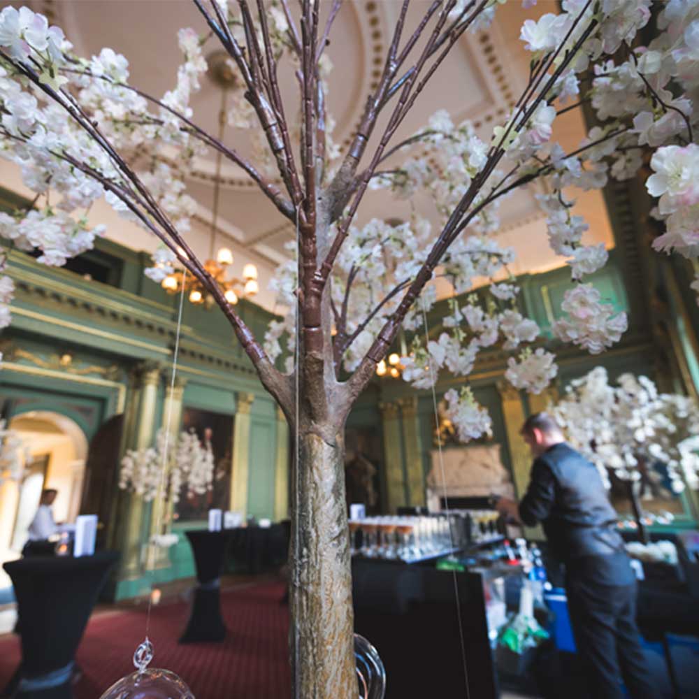 One of the rooms in the Mansion House is decorated for a wedding with a fake blossom tree hung with glass baubles and in the background a bar is being set up