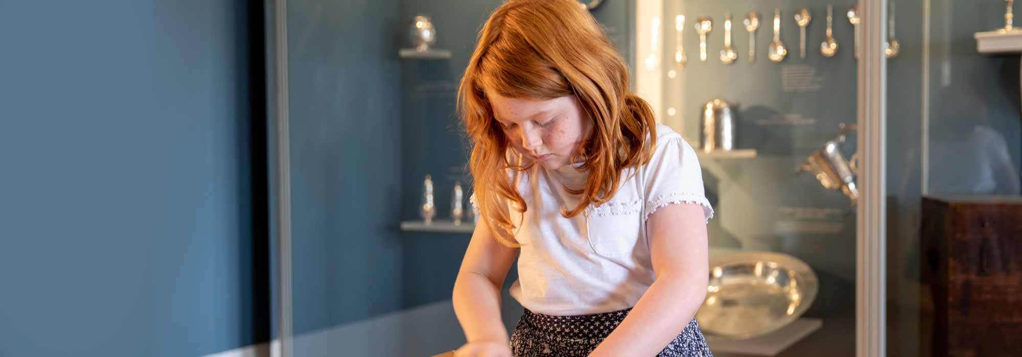 A little girl looks down a project she is working on